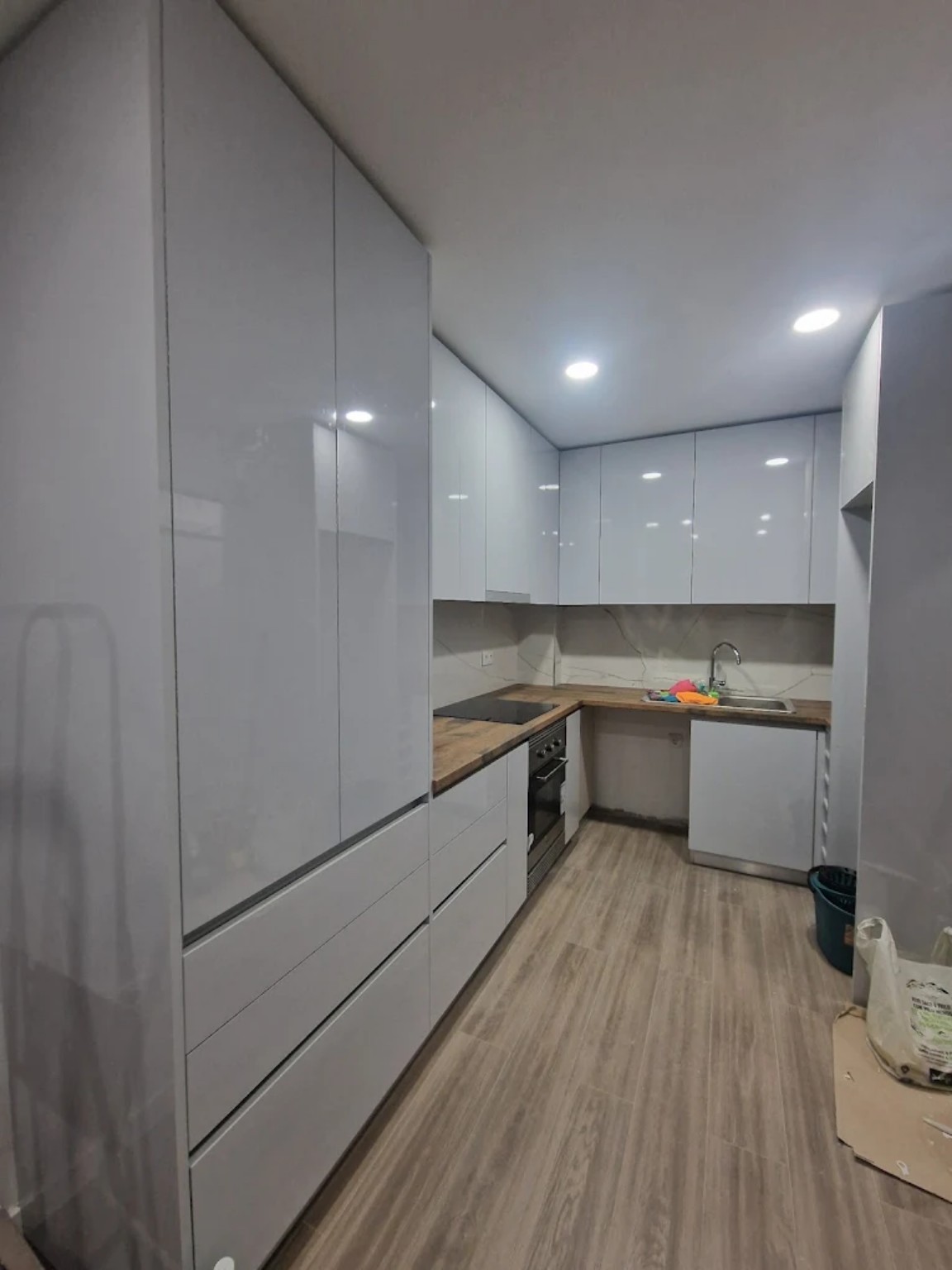 Cozinha compacta branca com bancada em madeira