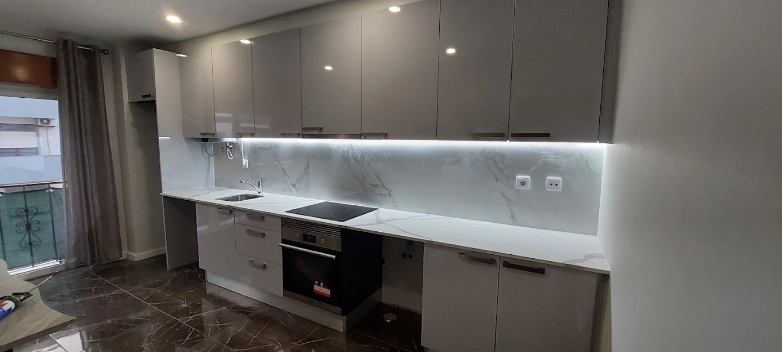 Cozinha contemporânea com armários cinza e iluminação LED