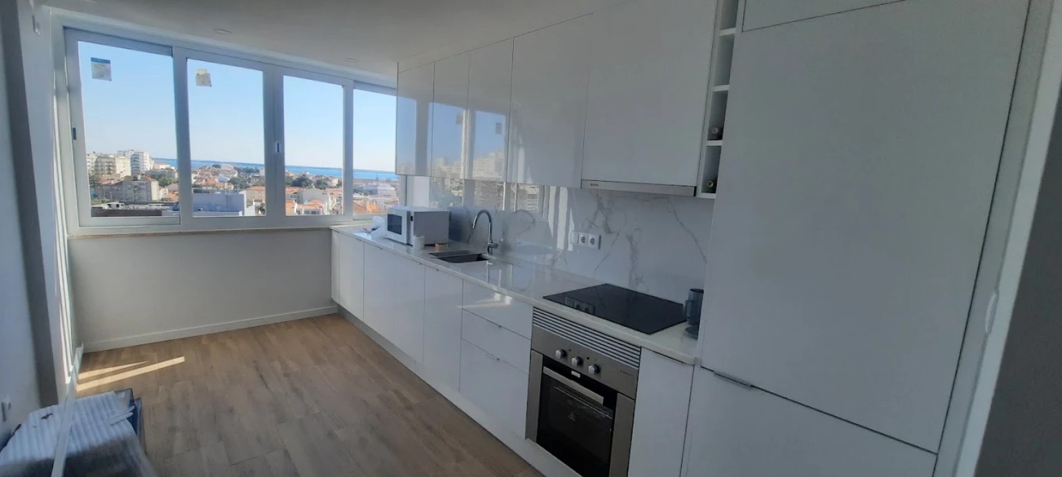 Cozinha branca moderna com janela e vista exterior